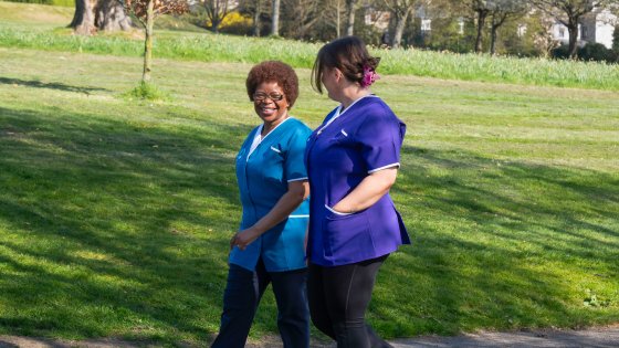 Leadcare Recruitment healthcare assistant (purple uniform) and nurse (blue uniform) walking in Northern Ireland.